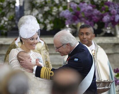 Carlos Gustavo de Suecia acaricia a su nieto Óscar, en brazos de su madre, tras el bautizo.