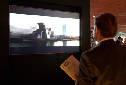 Un visitante contempla un vídeo sobre la ciudad de Bilbao en la exposición de los 40 años de El País.
