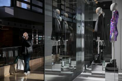 Una persona pasa delante del escaparate de una tienda en un centro comercial en Barcelona.