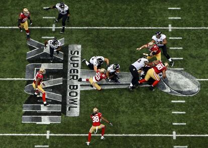 Ray Rice (27) de los Baltimore Ravens (en el centro de la imagen) busca el espacio abierto antes de chocar contra Patrick Willis (52), de San Francisco.