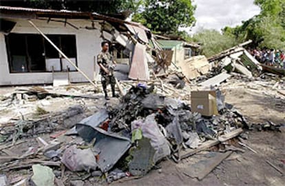 Un miembro de las fuerzas aéreas filipinas hace guardia ante los restos del avión siniestrado.