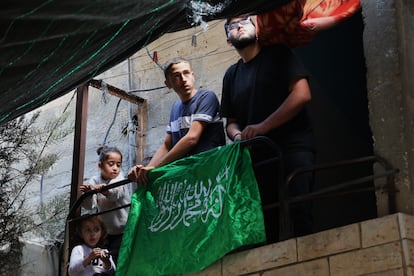 Unos palestinos colocan la bandera de Hamás en casa de una de las víctimas de la operación militar en Cisjordania, en el campo de refugiados de Nur Chams este domingo.