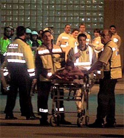 Los servicios sanitarios retiran a una persona herida leve durante la refriega.