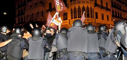 Varios policías forcejean con un grupo de sindicalistas en la puerta de la sede central de Correos de Valencia.