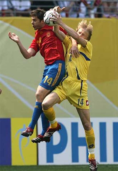 Xabi Alonso se disputa la pelota con Husin.