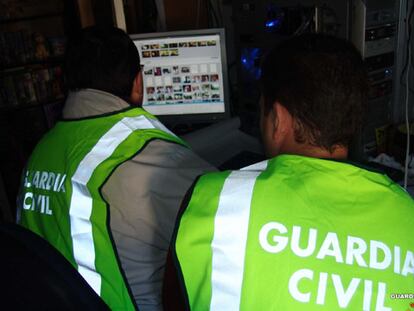 Varios agentes analizan uno de los equipos informáticos intervenidos.