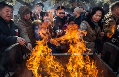 China inaugura hoy el año del 'mono de fuego' con numerosos festejos y con la esperanza de que este signo lunar traiga la buena suerte con la que se define en el zodiaco. En la imagen, varias personas encienden incienso en el templo Yongchegong Lama, en la ciudad de Pekín.