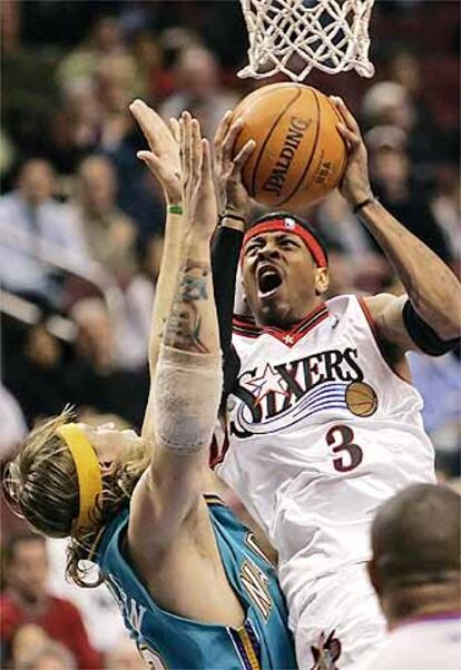 Iverson, de los Sixers, encara la canasta ante la presencia de Andersen, de los Hornets.