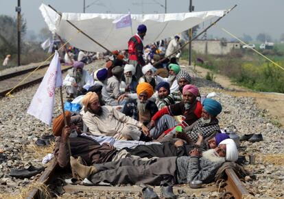 Agricultores y ganaderos descansan sobre vías del tren durante una protesta organizada en contra de las políticas del gobierno en Devi Dass Pur, a 20km de Srinagar (India).