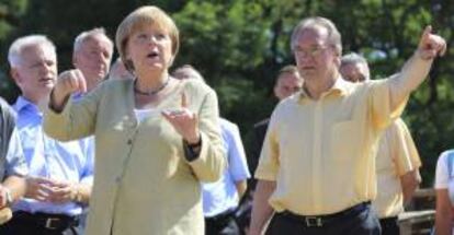 La canciller alemana, Angela Merkel (i), visita a los habitantes de una zona afectada por las inundaciones del pasado mes de junio, en Fischbeck (Alemania). EFE/Archivo