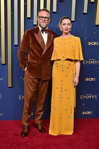 El actor canadiense Seth Rogen, con traje marrón de terciopelo, y su mujer Lauren Miller, con vestido mostaza. 