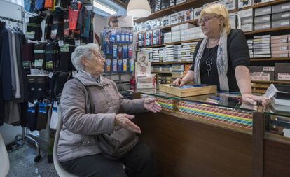 Angela Velasco, usuaria del proyecto Radars de Barcelona, charla con Vivian Cartes, que regenta una mercería en su barrio