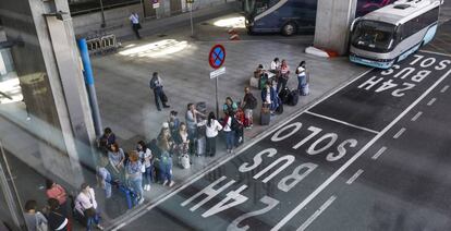 Viajeros esperando un autobús en el aeropuerto de Barajas, en Madrid.