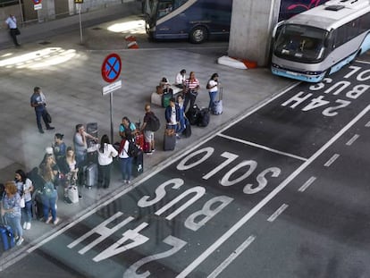 Viajeros esperando un autobús en el aeropuerto de Barajas, en Madrid.