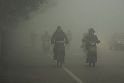 Motoristas avanzan en medio del aire contaminado en Huaibei, en el centro de China.