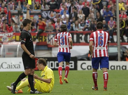 Gil Manzano muestra la tarjeta amarilla al centrocampista del Atlético de Madrid Koke después de una falta a Pina