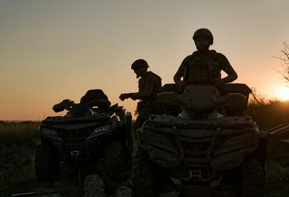 Ukrainian soldiers ride all-terrain vehicles at the front line near Bakhmut