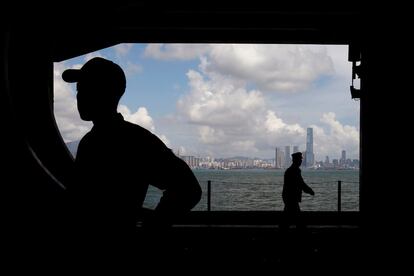 Varios miembros de la tripulación del portaaviones USS Ronald Reagan esperan en el hangar mientras llegan al puerto de Hong Kong.