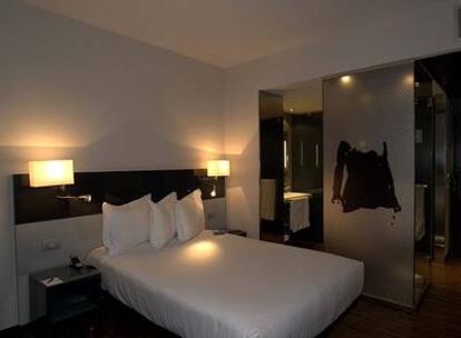 Habitación del AC Feria de Madrid, con la ducha como pieza independiente entre la cama y la zona de aseo.