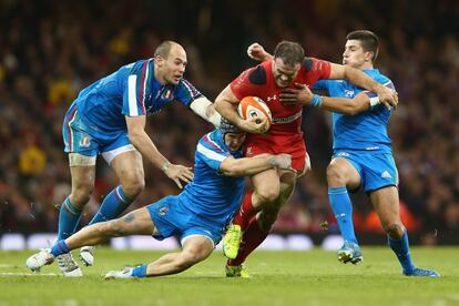 Jamie Roberts, de Gales, trata de zafarse de varios jugadores italianos en el partido del Seis Naciones.