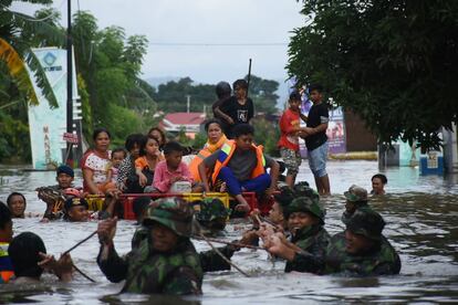 Soldados indonesios evacuan a los residentes afectados por las inundaciones en Makassar.