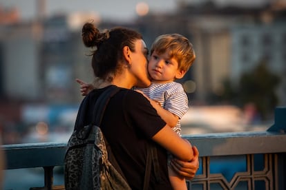 Una mujer besa a un niño.