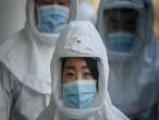 In this photo taken on March 12, 2020, medical workers wearing protective clothing against the COVID-19 novel coronavirus walk to a decontamination area at the Keimyung University hospital in Daegu. - South Korea -- once the largest coronavirus outbreak outside China -- saw its newly recovered patients exceed fresh infections for the first time on March 13, as it reported its lowest number of new cases for three weeks. (Photo by Ed JONES / AFP)