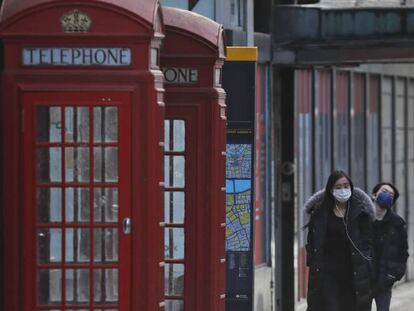 Varias personas andan por las calles vacías de Londres, que tiene cerrados los establecimientos por la pandemia.