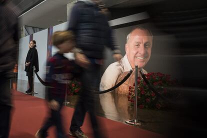 Varios aficionados pasan por delante del retrato de Cruyff. 