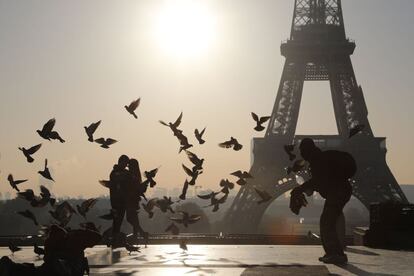 Una pareja posa para una fotografía en la plaza Trocadero frente a la torre Eiffel, en París (Francia).