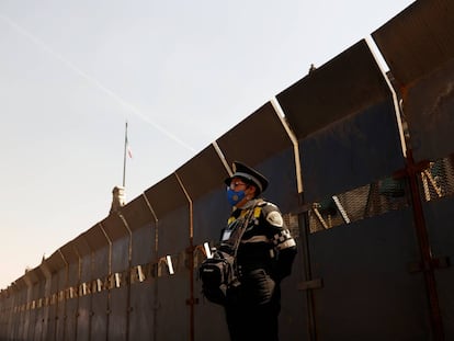 Un oficial de policía monta guardia junto a las cercas colocadas afuera del Palacio Nacional antes de la violencia esperada en una protesta por el Día de la Mujer, en la Ciudad de México