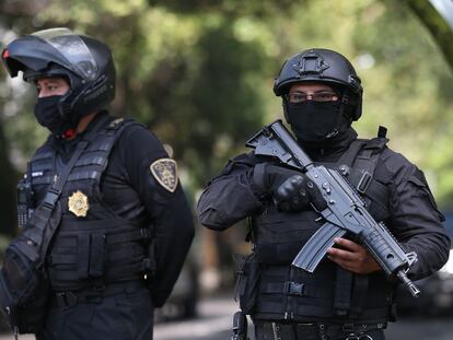 Dos agentes de la policía capitalina resguardan la zona del atentado por parte de un grupo armado al secretario de seguridad ciudadana, Omar García Harfuch, la mañana del 27 de julio de 2020 en Ciudad de México (México).