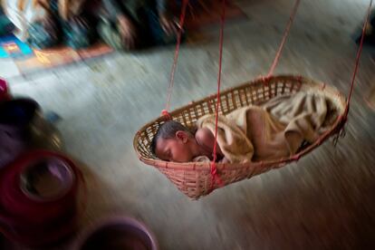 Un niño refugiado rohingya duerme en una cuna en una casa improvisada en el campo de Kutupalong (Bangladés) el 28 de abril de 2018. La estación de lluvias torrenciales se alargará todo el verano y amenaza la débil infraestructura del campo y la delicada salud de sus habitantes. Además de reubicar a las personas que viven en las zonas con mayor riesgo de inundación, las organizaciones humanitarias están trabajando para garantizar garantizar el suministro de agua y que las potabilizadoras resistan.