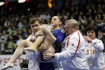 Mustafina es retirada en brazos por sus entrenadores.