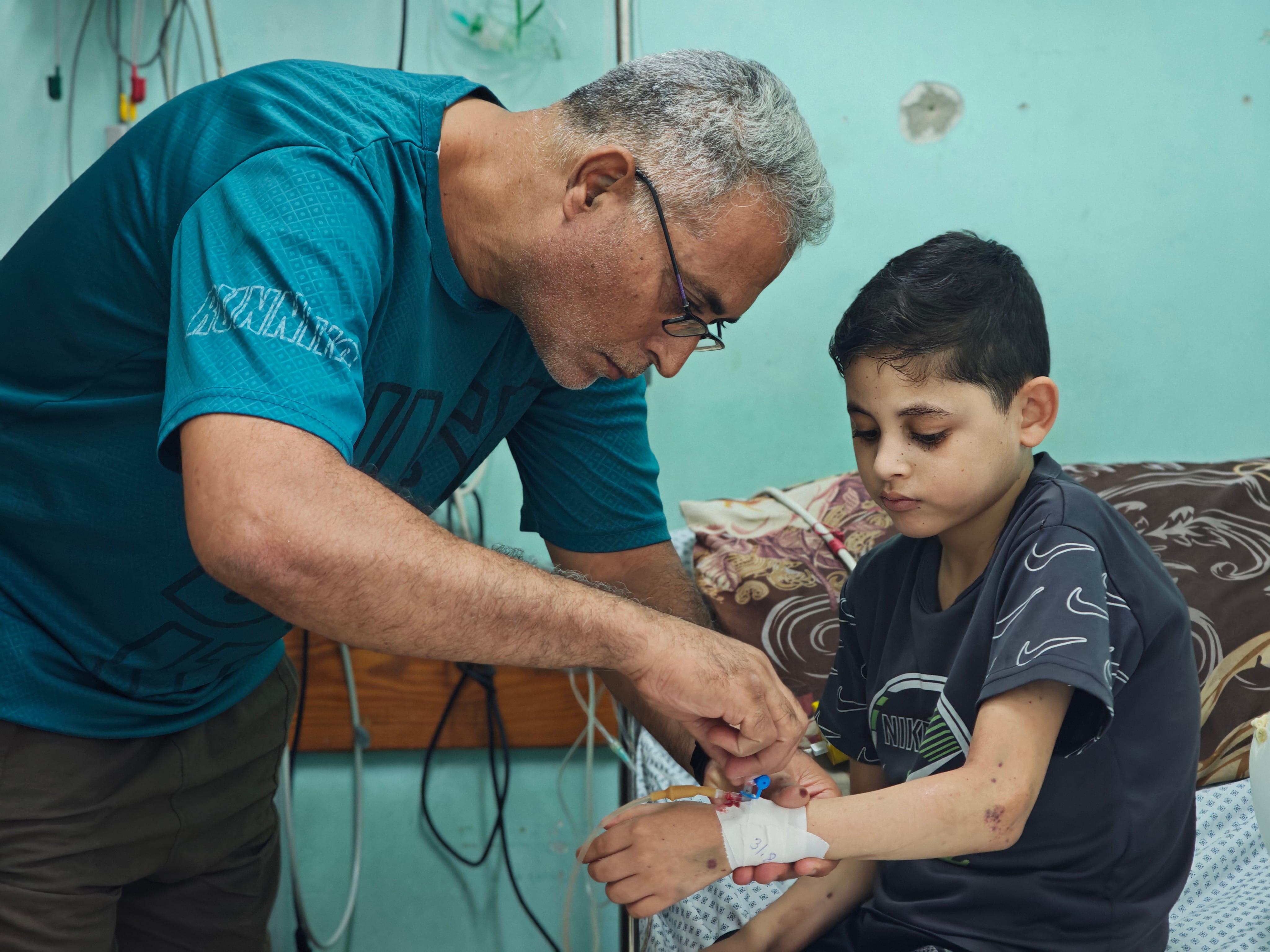 Rafat Abu Shawish, con su hijo Muath, en el hospital de los Mártires de Al Aqsa, en Deir El Balah (Gaza), este lunes.