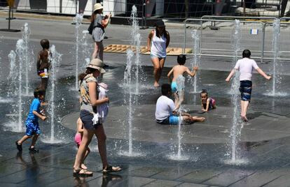 Un grupo de niños se refresca en una fuente pública de Montreal.