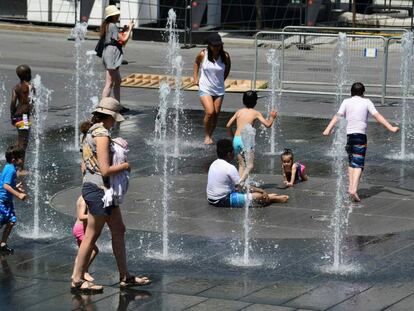 Un grupo de niños se refresca en una fuente pública de Montreal.