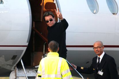 El intérprete, conocido como el Elvis francés, saluda a los fotógrafos en el aeropuerto Bourget cerca de París. 