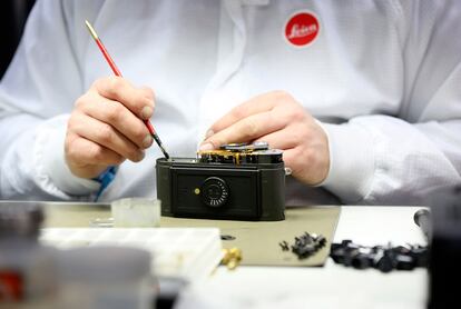 Un técnico trabaja en el montaje de una Leica M7 analógica. El trabajo es manual y preciso. La llegada de las cámaras Leica de 35 mm supuso una revolución en el mundo del fotoperiodismo, ya que reducía el tamaño y peso de las cámaras, mejorando en algunos casos la calidad de sus cámaras contemporáneas.