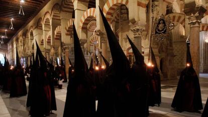 Nazarenos de la Hermandad de la las Penas de Santiago durante su estación de penitencia en el interior de la Mezquita de Córdoba.