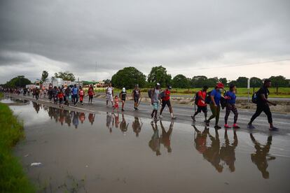 Migrantes de Centroamérica y Haití caminan en caravana en una carretera en Escuintla, Chiapas (México).