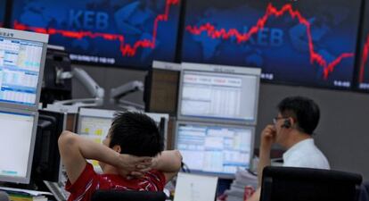 Corredores de bolsa surcoreanos vigilan las pantallas en Seúl