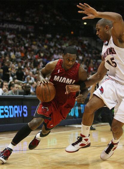 Mario Chalmers, de los Miami Heat, protege el balón ante Al Horford, de los Atlanta Hawks.