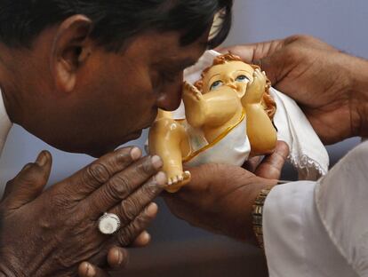Un hombre besa una figura del niño Jesús en una iglesia de Ahmedabad, India.