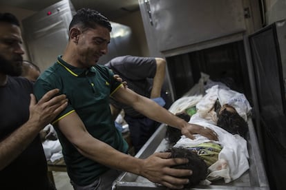 Un familiar llora junto a los cuerpos sin vida de cuatro hermanos encontrados entre los escombros de una casa durante los ataques israelís en Beit Lahiya, al norte de Gaza. Israel ha lanzado a primera hora de la madrugada de este viernes una ofensiva a gran escala por tierra y aire contra Hamás, en una intervención sin precedentes desde la guerra de 2014.