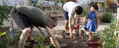 Una familia trabaja en un huerto ocupado en Barcelona.