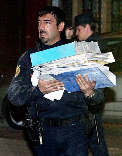 Un agente policial lleva documentos relacionados con el atentado, relacionado con los que produjeron el 11 de marzo en Madrid.