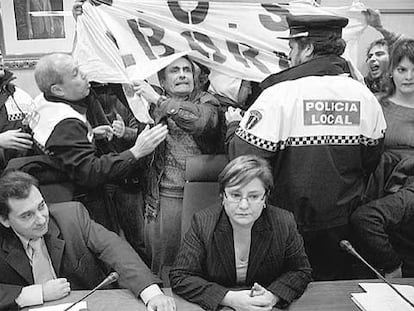 El alcalde de Alboraia, Manuel Álvaro, sentado, ayer, mientras la policía local forcejea con un grupo de agricultores y jóvenes.