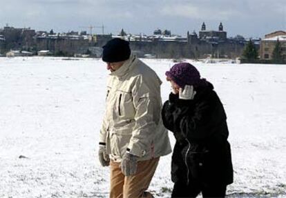 Una pareja camina en Pamplona, donde la ola de frío ha cubierto la ciudad de una espesa capa de nieve.