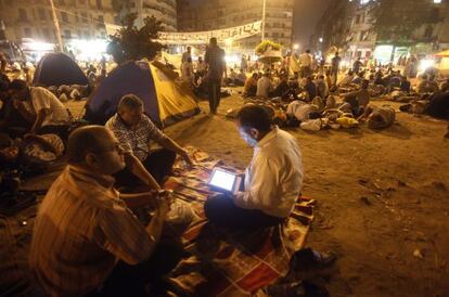 Un manifestante lee en su tableta en la plaza Tahrir de El Cairo (Egipto). 